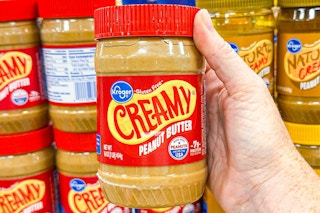 hand holding a jar of kroger peanut butter