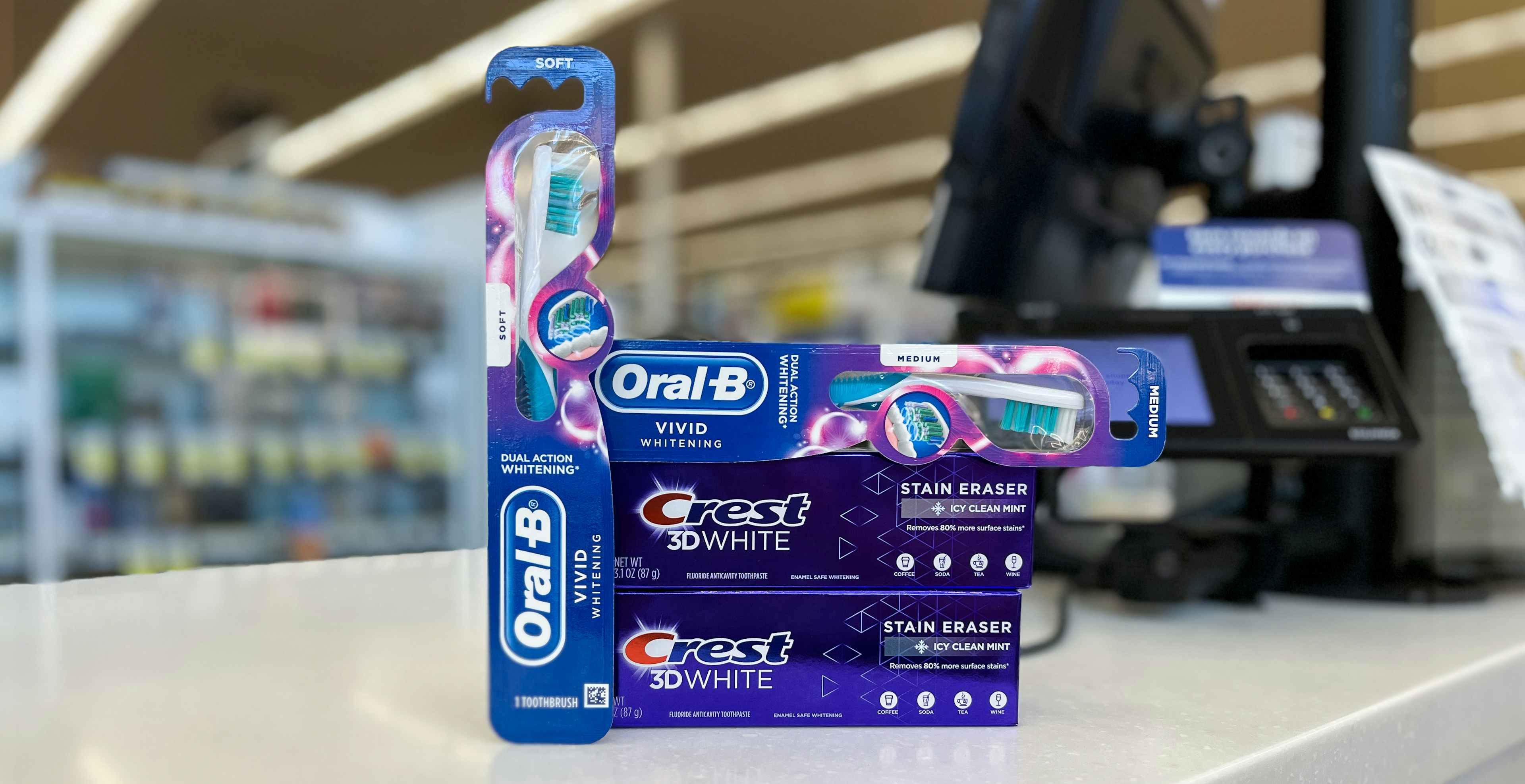 crest 3d white stain eraser toothpaste and oral-b vivid whitening toothbrush on a checkout counter