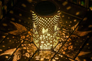 a hummingbird lantern on a deck