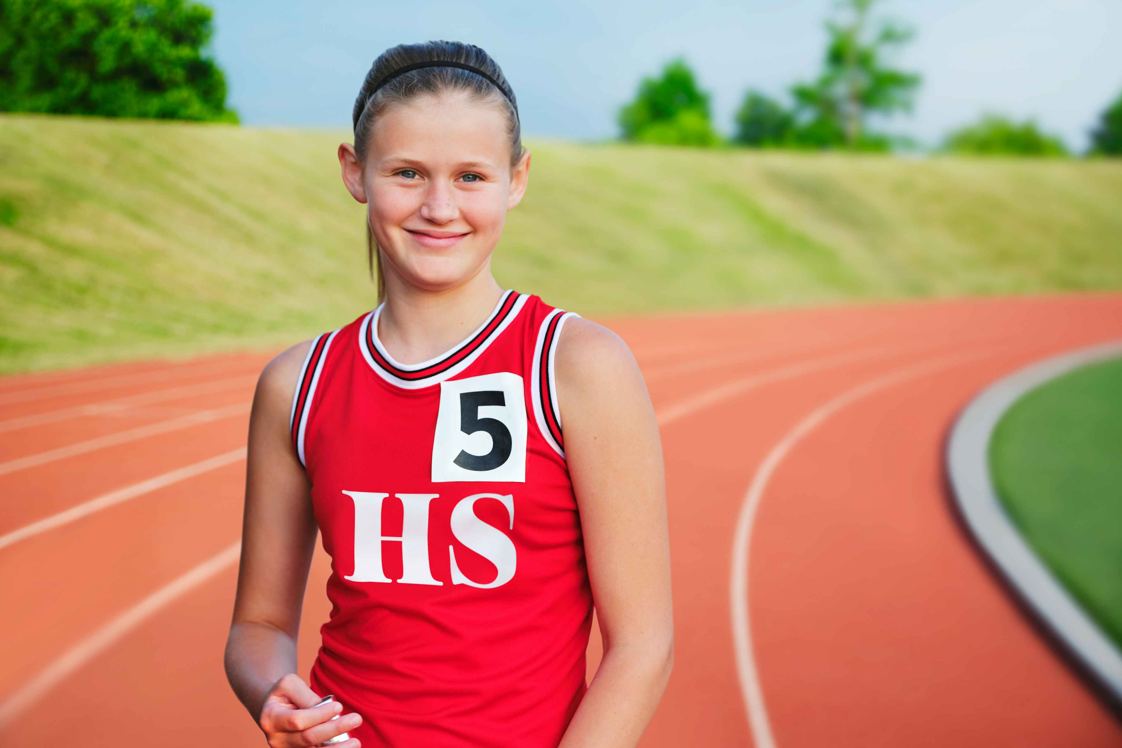a young girl in a track uniform on a track