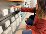 a person picking up a box of Apple Airpods in a store