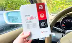 hand holding a walgreens photo packet in a car