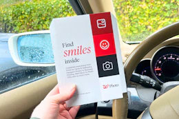 hand holding a walgreens photo packet in a car