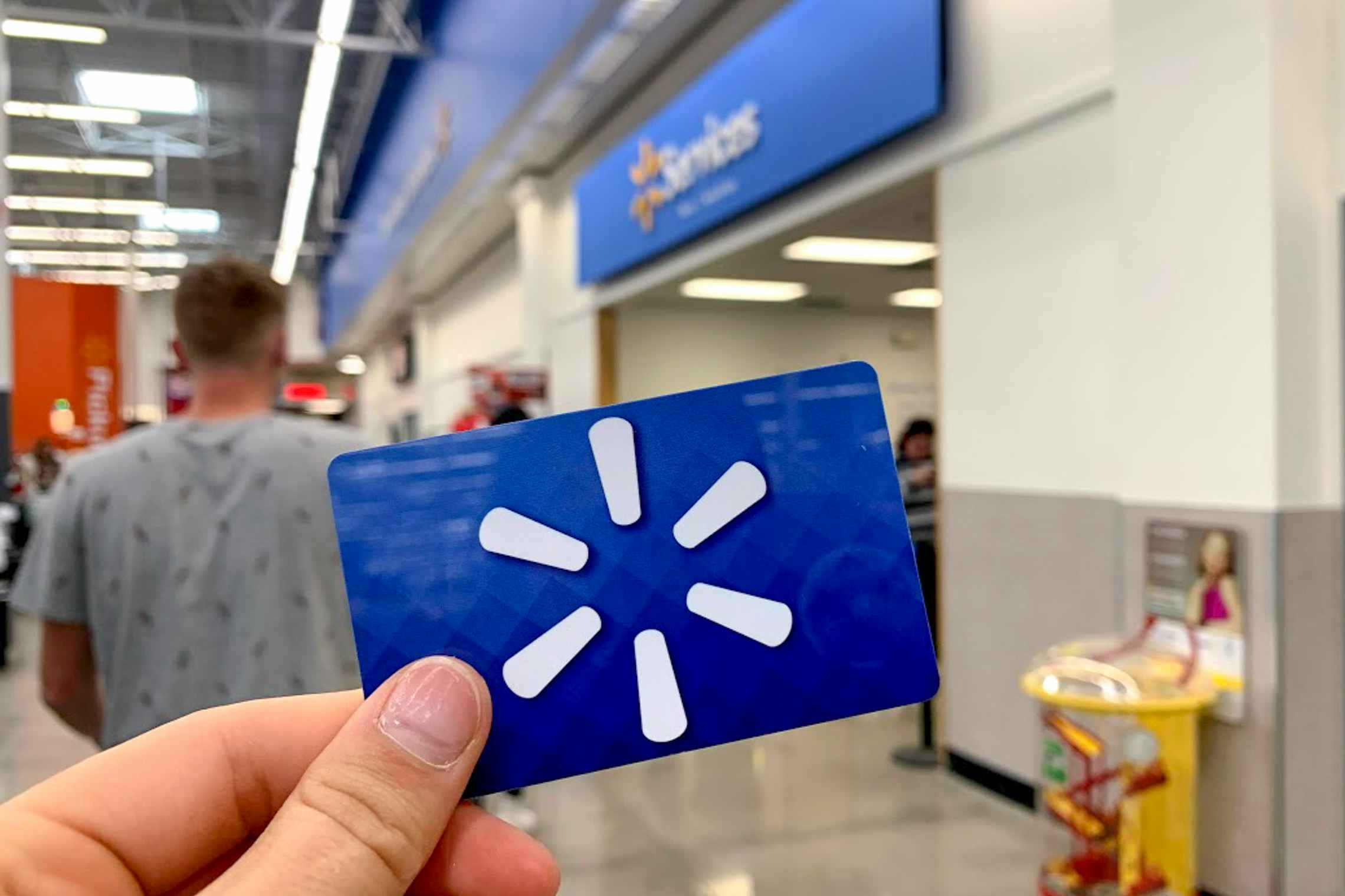 Walmart gift card held up in front of service center