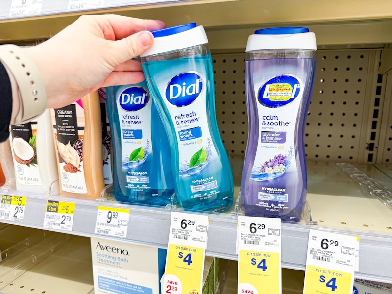person grabbing a bottle of dial body wash off the shelf