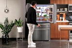 Lifestyle image of the GE French Door Refrigerator being opened to showcase LED wall 