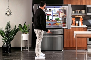 Lifestyle image of the GE French Door Refrigerator being opened to showcase LED wall 