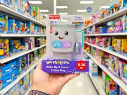 hand holding fisher price coffee mug in aisle