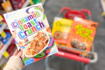 hand holding a box of cinnamon toast crunch cereal
