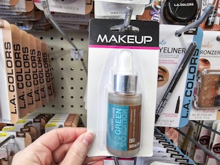 person grabbing a maybelline foundation off a hook at dollar tree