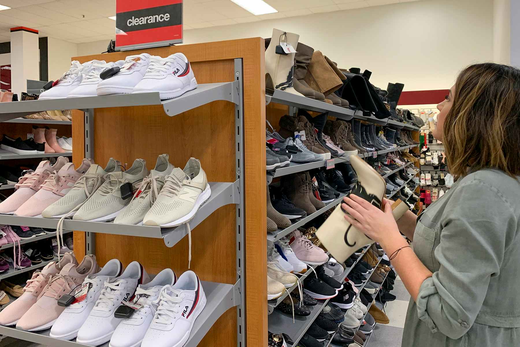 A woman searching through clearance shoes.