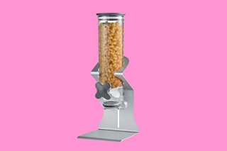 A cereal dispenser on a pink background