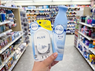 hand holding febreze plug in and air freshener in walgreens