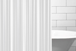 A clear frosted shower curtain liner hangs in front of an apparent claw-foot tub.