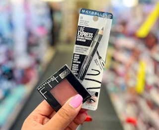 hand holding Maybelline fit me blush and Maybelline Line Express eyeliner