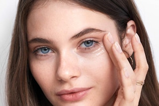 a woman applying olay eye gel