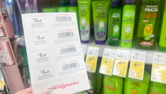 hand holding walgreens store coupons in front of garnier products