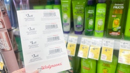 hand holding walgreens store coupons in front of garnier products