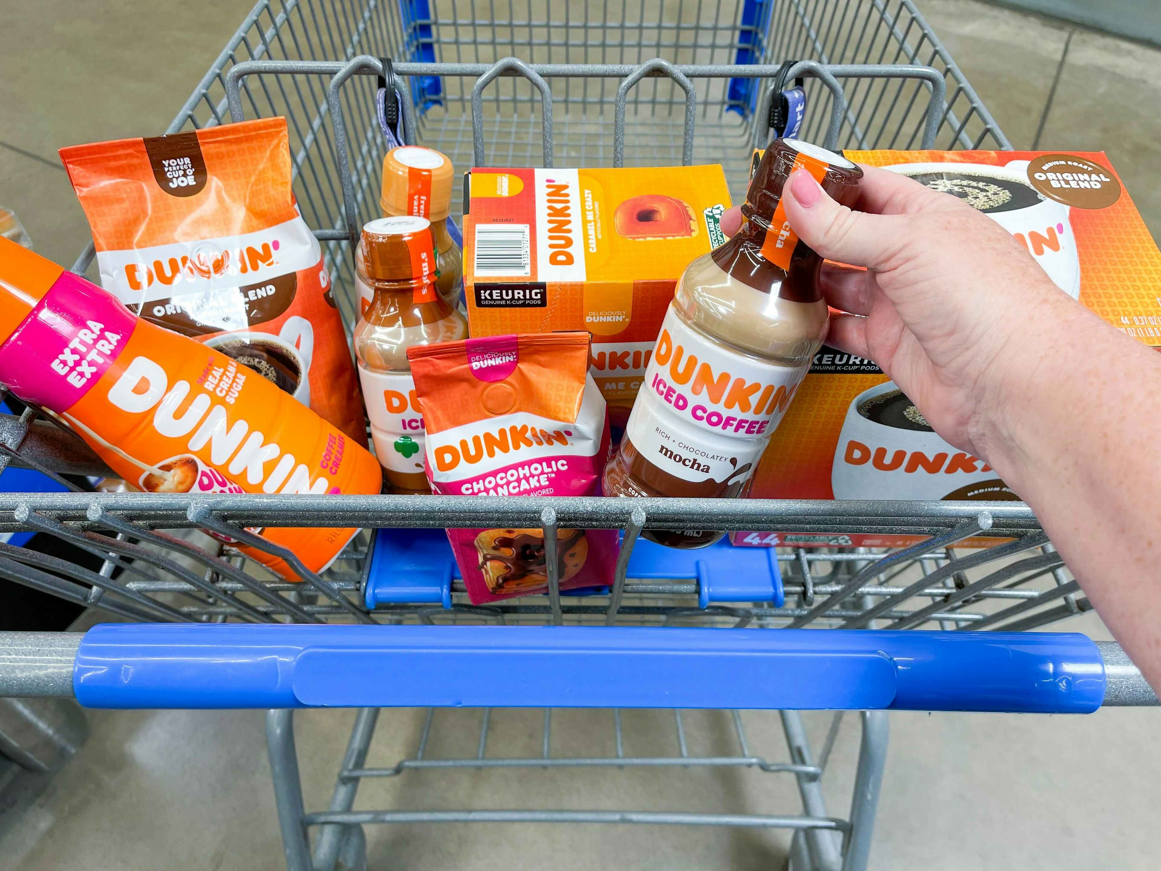 A Walmart shopping cart basket full of the different Dunkin brand items that are available at Walmart.