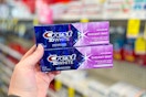 person holding 2 crest 3d white toothpastes