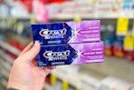 person holding 2 crest 3d white toothpastes