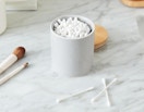 cotton swabs in a small jar on a marble counter