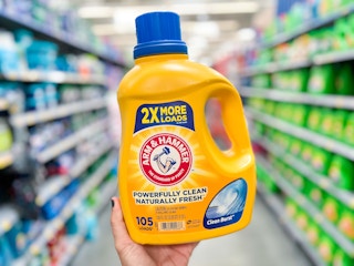 person holding a bottle of Arm & Hammer detergent