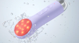 a purple LED cleansing brush in water