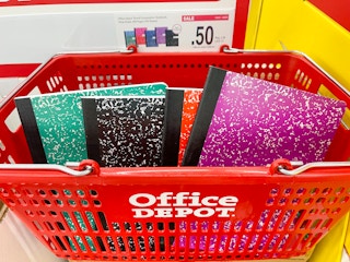 A red office depot basket full of notebooks.