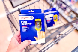 person holding a pulse oximeter over a cart