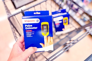 person holding a pulse oximeter over a cart