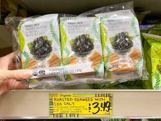 hand grabbing trader joes organic roasted seaweed with sea salt snack
