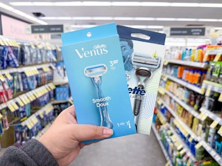 hand holding gillette and venus razors in walgreens