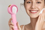 woman holding facial cleansing brush