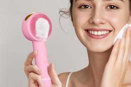 woman holding facial cleansing brush