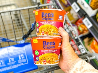 hand holding two cups of rice