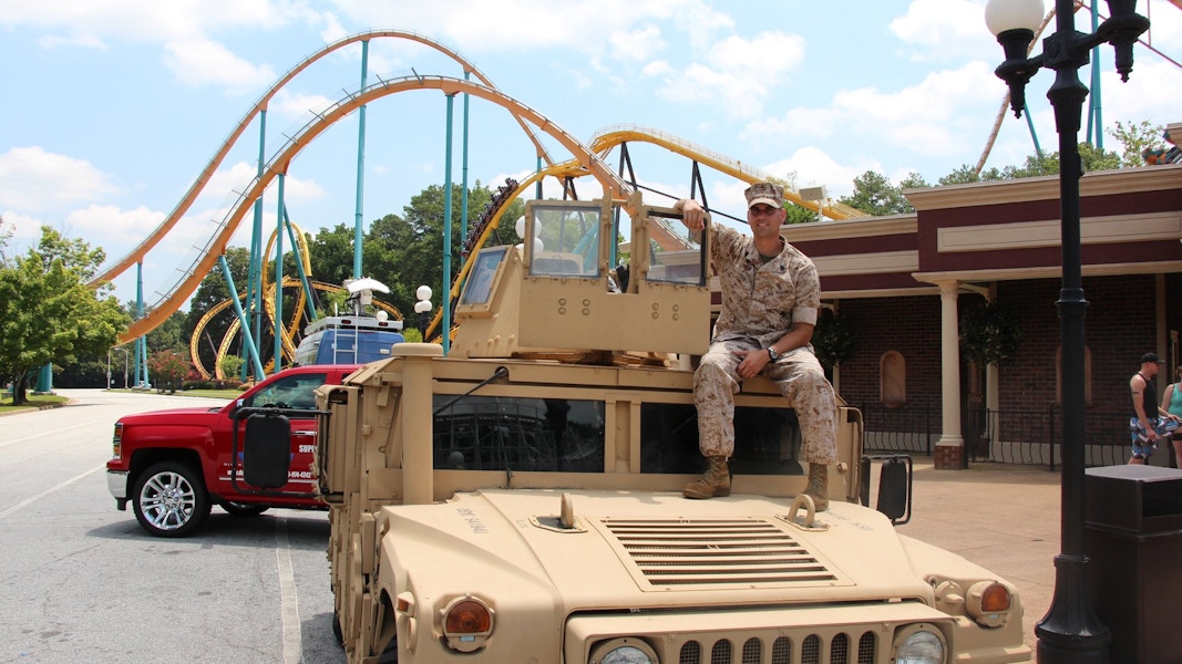 someone in a military uniform sitting on military truck next to Disneyland