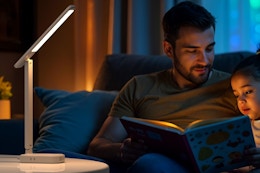 a man and child reading under a lamp
