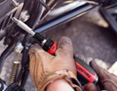 a person using a ratcheting screwdriver on a machine