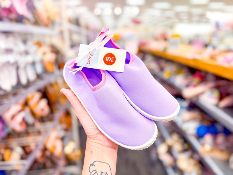 hand holding a pair of water shoes in target aisle