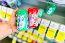 person holding 2 packs of mentos gum