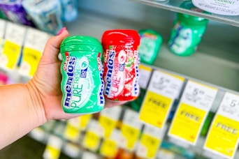 person holding 2 packs of mentos gum