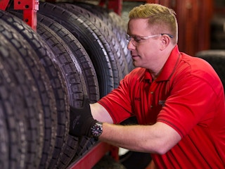 A Discount Tire employee taking a tire from a shelf