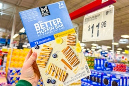 hand holding a box of members mark better muffin bars