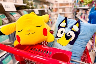 pokemon and bluey plush pillows sitting on a target cart