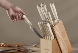 hand pulling out a knife from a wood block