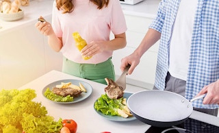 a couple cooking with a fry pan