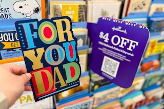 hand holding card in greeting card aisle next to sign