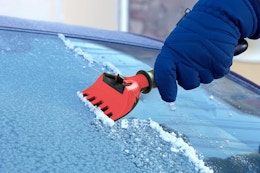 a hand using an ice scraper