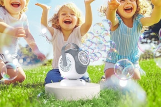 children playing with bubble machine outside
